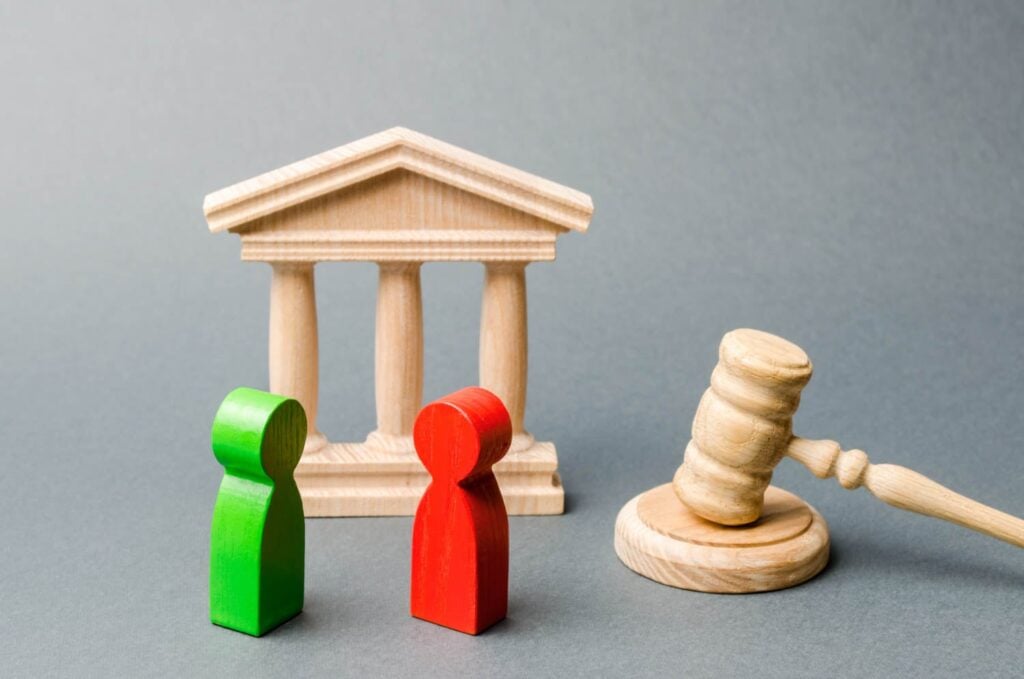 Wooden Figures Of People Standing Near The Judge